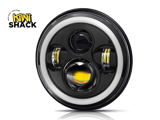 Car headlight with black casing and white rim, featuring Kiwi Shack logo.