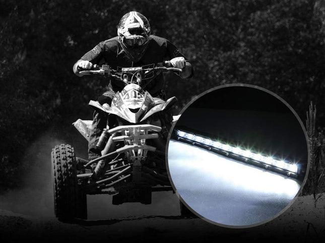 Person riding an ATV at night with a close-up of a light source.