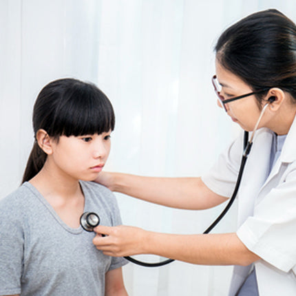 Doctor using a stethoscope on a patient in a clinical setting