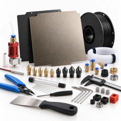 An assortment of 3D printer parts and maintenance accessories, including print beds, filament rolls, a hotend assembly, various nozzles, tubes, a digital caliper, tools, and connectors on a white background.