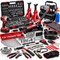 An assortment of automotive tools and equipment, including a hydraulic floor jack, jack stands, socket sets, wrenches, a creeper, an air compressor, a power drill, hammers, pliers, and a torque wrench on a white background.
