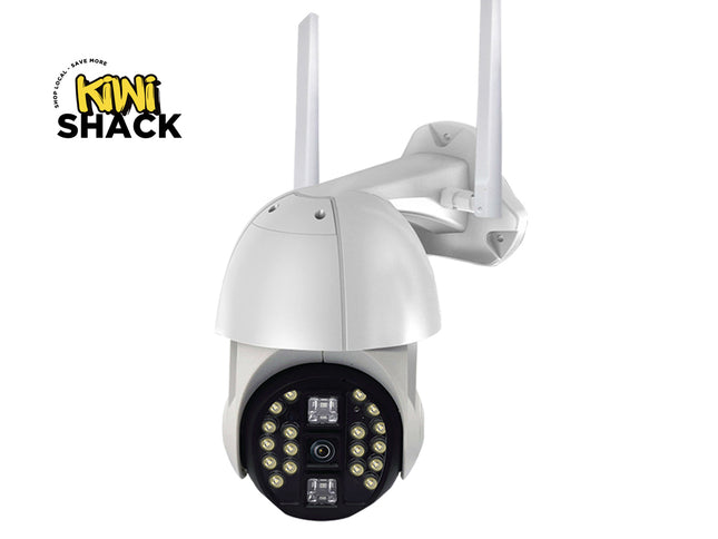 A white outdoor security camera with two antennas, a black circular faceplate containing multiple LED light elements, and a wall mounting bracket, shown on a white background with a Kiwi Shack logo in the top-left corner.