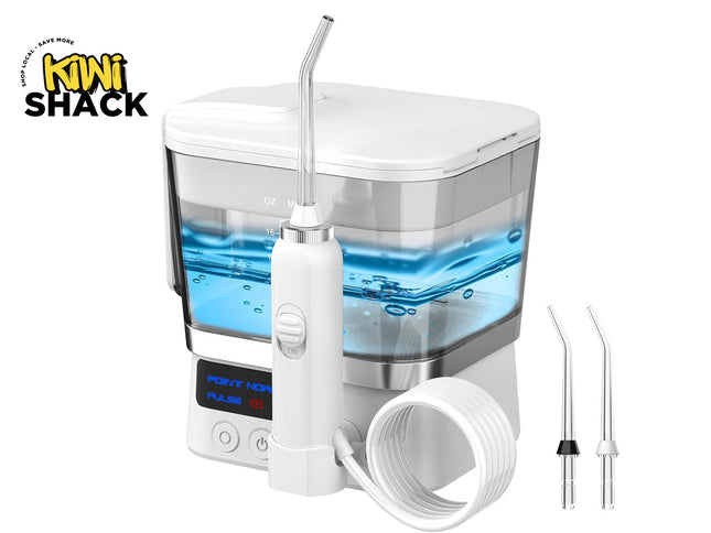 White and silver Kiwi Shack oral irrigator water flosser with a clear water tank filled with blue water, shown with two nozzle tips, a coiled white hose, and the Kiwi Shack logo in the top left corner.