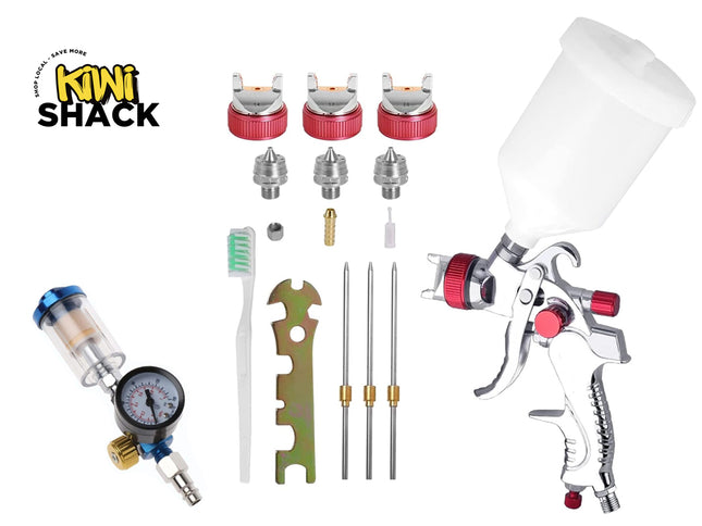 Kiwi Shack spray paint kit with a silver spray gun, white paint cup, air regulator, brush, metal tips, and red nozzles on a white background.