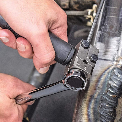 Person using a wrench on a mechanical component.