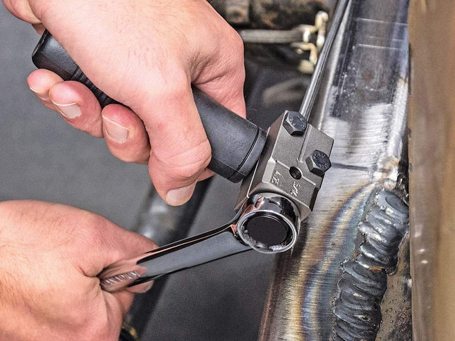 Person using a wrench on a mechanical component.