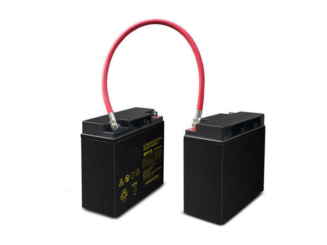 Two black batteries with red and black cables on a white background