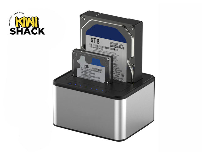 A silver and black dual-bay hard drive docking station holding a larger 3.5-inch desktop hard drive and a smaller 2.5-inch laptop hard drive with blue status indicator lights, featuring a "Kiwi Shack" logo in the top left corner.