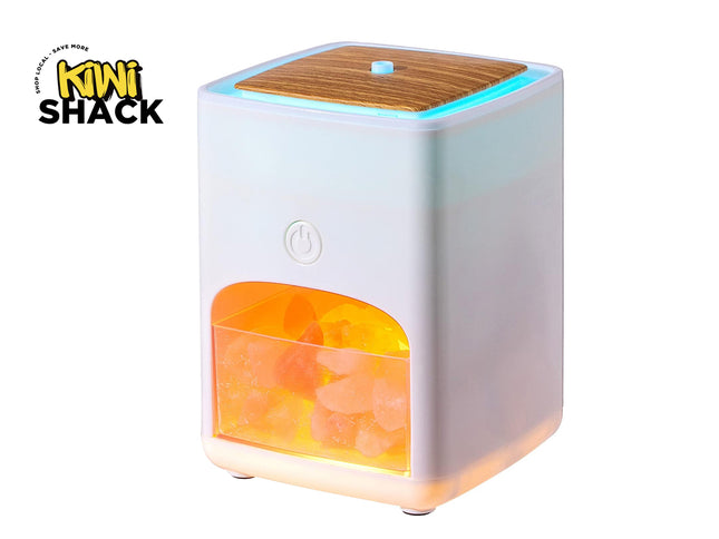 A Kiwi Shack portable humidifier and diffuser with a white body, a wood-grain top panel, and an illuminated orange salt crystal chamber, shown on a white background with the Kiwi Shack logo in the top-left corner.