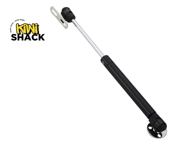 Black gas strut with silver rod on a white background, branded with 'Kiwi Shack'.
