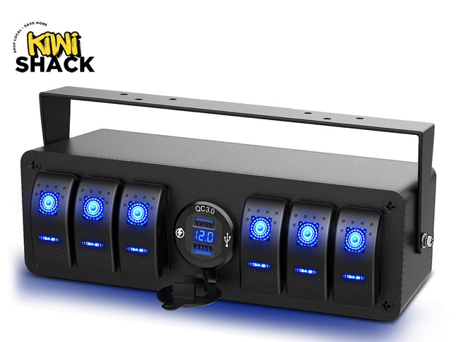 A black multi-gang rocker switch panel with blue backlit LED switches, a central QC 3.0 dual USB charger socket with a digital voltmeter display, and an overhead mounting bracket, featuring a "Kiwi Shack" logo in the top left corner.
