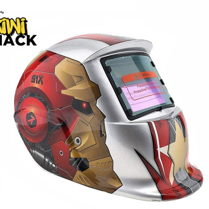 An auto-darkening welding helmet featuring a silver, red, and gold comic-book-inspired robotic armor graphic design, an auto-darkening viewing window, and mechanical details against a white background, with the "Kiwi Shack" logo in the upper left corner.