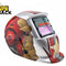 An auto-darkening welding helmet featuring a silver, red, and gold comic-book-inspired robotic armor graphic design, an auto-darkening viewing window, and mechanical details against a white background, with the "Kiwi Shack" logo in the upper left corner.