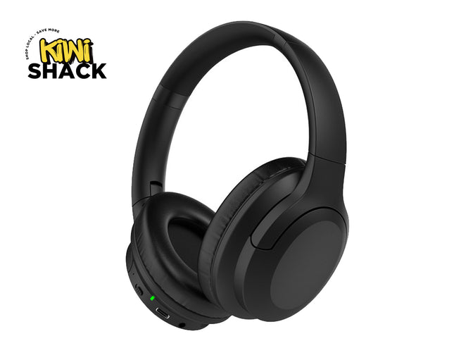 A pair of matte black over-ear wireless headphones featuring plush cushioned ear pads, physical control buttons, a charging port, and an active status indicator light, set against a white background. A "Kiwi Shack" logo appears in the top-left corner.