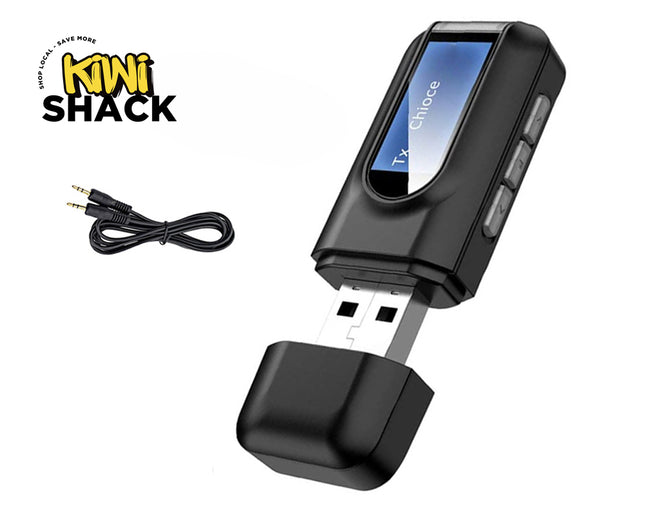A black USB Bluetooth audio transmitter device with an LCD screen, control buttons along the side, an uncapped USB connector, and an accompanying 3.5mm auxiliary audio cable against a white background, featuring the "Kiwi Shack" logo in the upper left corner.