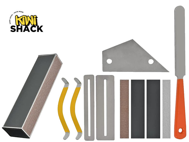A Kiwi Shack sharpening and sanding kit with multiple tools arranged on a white background, including a sharpening stone, yellow-handled sharpening bars, metal guide pieces, sanding belts, and a metal scraper with an orange handle.