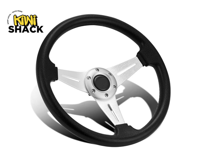 Black and silver steering wheel with 'Kiwi Shack' logo in the corner