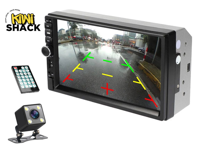 A car multimedia head unit and backup camera kit featuring a double-DIN stereo display with a rear-view parking guide overlay, a small cube-shaped backup camera with built-in LED lights, and a wireless remote control against a white background, with the "Kiwi Shack" logo in the upper left corner.