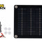 A square solar panel kit with four corner mounting grommets, accompanied by a cigarette lighter adapter cable, battery alligator clips, and four suction cups, with a "Kiwi Shack" logo in the top left corner.