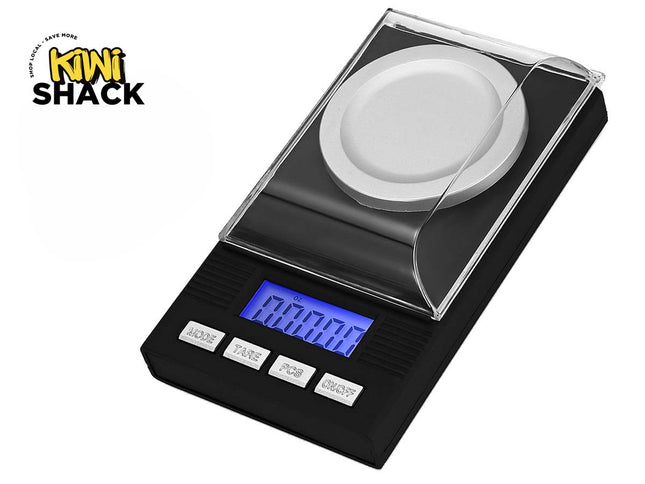 A black digital pocket scale with a clear protective cover, a silver weighing platform, and a blue backlit LCD display, shown on a white background with the Kiwi Shack logo in the top-left corner.