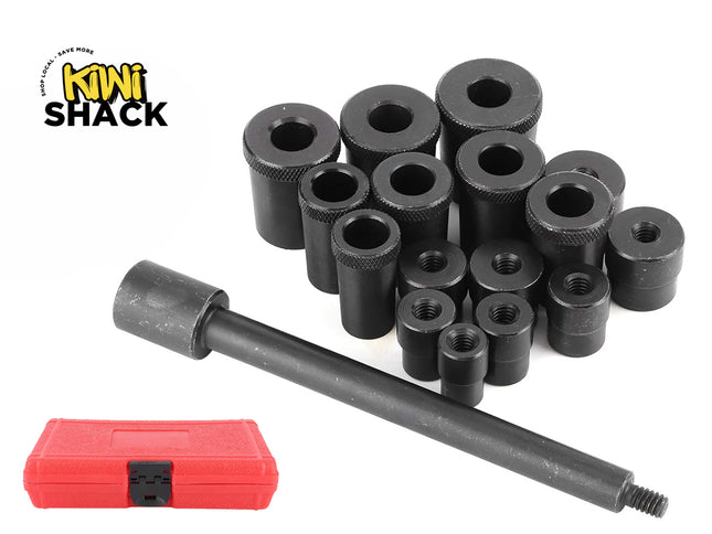 A set of black metal automotive bushing driver and removal tools, including various sized cylindrical adapters and a threaded handle rod next to a closed red storage case, set against a plain background with the "Kiwi Shack" logo in the top left corner.