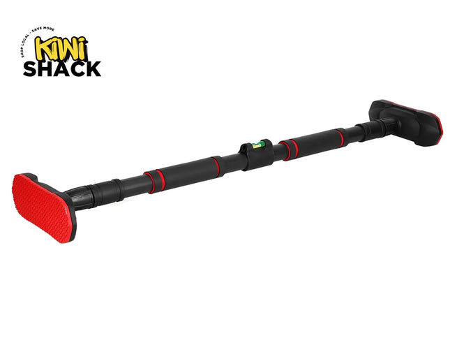 A black and red adjustable doorway pull-up bar featuring foam grips, wide non-slip textured rubber end pads, and a built-in bubble level in the center, with a "Kiwi Shack" logo in the top left corner.