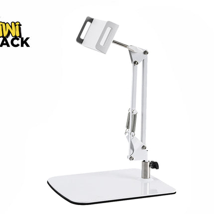 A white articulated desktop arm stand for a phone or tablet, featuring a heavy flat base, an adjustable spring-assisted mechanical arm, and a secure mounting clamp at the top, set against a plain white background with the "Kiwi Shack" logo in the top left corner.