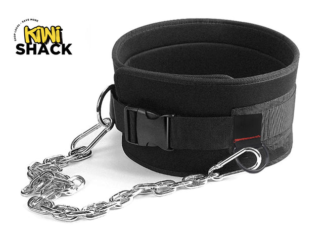 Black padded weightlifting dipping belt with a quick-release buckle strap, heavy-duty steel load-bearing chain attached with D-rings and carabiners, and the Kiwi Shack logo watermark.