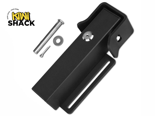 A black metal locking bracket device with an integrated keyhole cylinder, displayed with a silver clevis pin, washer, and cotter pin, with a "Kiwi Shack" logo in the top left corner.