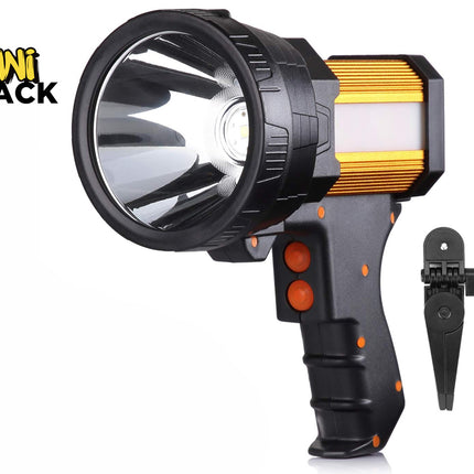 A black and gold high-intensity LED spotlight with a pistol-grip handle, orange control buttons, a side floodlight panel, and a small folding tripod stand on the right, set against a white background with the "Kiwi Shack" logo in the top left corner.