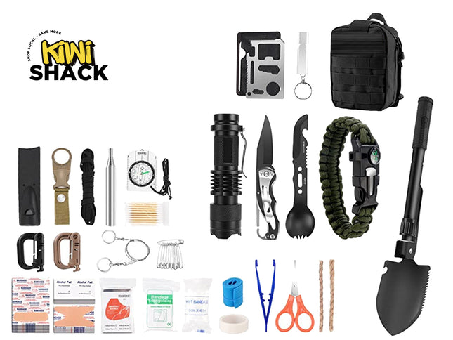 A comprehensive outdoor survival kit from Kiwi Shack, featuring a wide array of survival tools, first aid items, and accessories neatly arranged on a solid white background. The kit includes a black tactical backpack, a black folding shovel, a black flashlight, a black multi-tool knife, a green paracord bracelet, a black whistle, a compass, a first aid kit, and various other survival accessories.