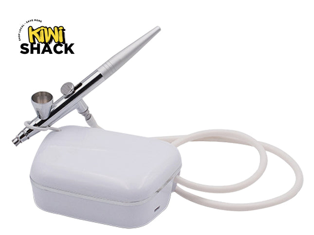 Airbrush with white case and cable on a white background, featuring Kiwi Shack logo.