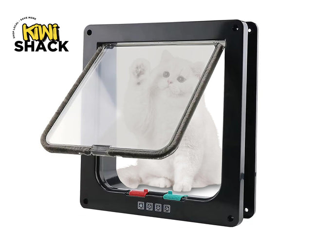 Black square pet cat door / flapped pet entry door installed in a frame with a clear pivoting transparent flap featuring a brush-sealed edge, colored locking latches at the bottom, a white cat sitting behind/visible through the transparency, and the Kiwi Shack logo watermark.