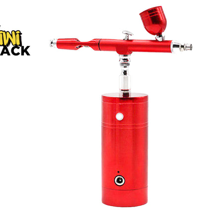 A red airbrush air compressor with a matching red cup and silver metal components, shown on a white background with the Kiwi Shack logo in the top-left corner.