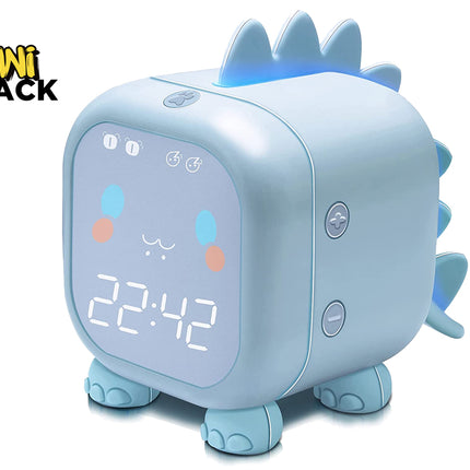 A light blue dinosaur-shaped digital alarm clock featuring a glowing face with a time display, cute facial expressions, soft spikes along the back, and small elephant-like feet against a white background, featuring the "Kiwi Shack" logo in the upper left corner.