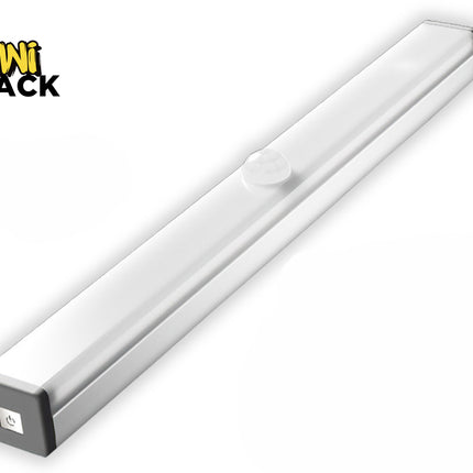 A slim, elongated LED under-cabinet light bar with a silver body and a frosted white cover featuring a circular motion sensor dome on top, along with a power button visible on the gray end cap, featuring a "Kiwi Shack" logo in the top left corner.