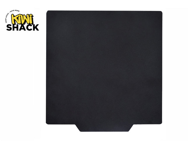 A square matte black stove mat with a bottom center cutout tab against a white background. A "Kiwi Shack" logo appears in the top-left corner.