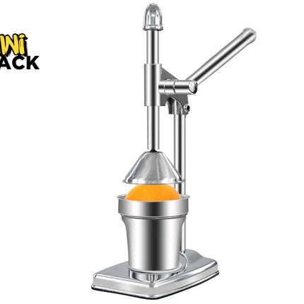 A stainless steel manual mini citrus juicer with a lever arm and cone press, shown with an orange inside the collection cup on a white background. The 'Kini Shack' brand logo is visible in the top-left corner.
