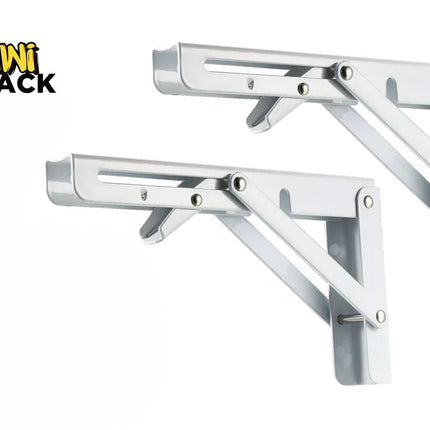 A pair of folding white metal shelf brackets with adjustable support arms and wall mounting plates against a white background, featuring the "Kiwi Shack" logo in the upper left corner.