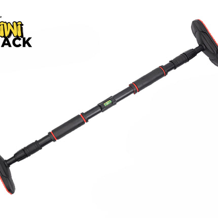 An adjustable black and red doorway pull-up bar angled across a white background, featuring extended non-slip textured rubber base pads at both ends and a built-in bubble level near the center, with a "Kiwi Shack" logo in the top left corner.