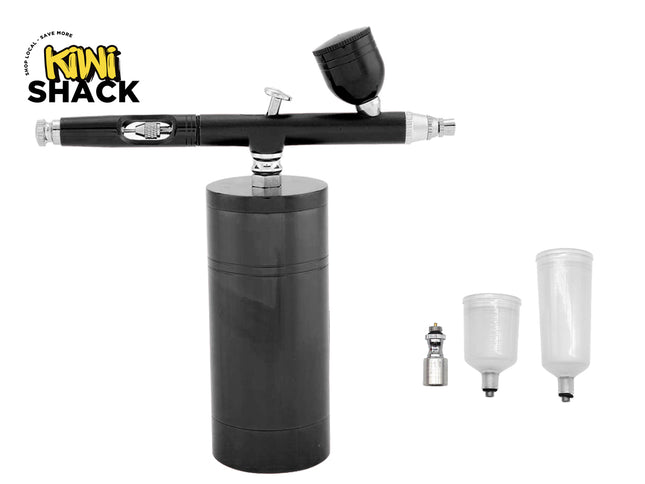 A black Kiwi Shack airbrush with a black cylindrical base, shown on a white background with three clear plastic paint cups and a small metal tip included.