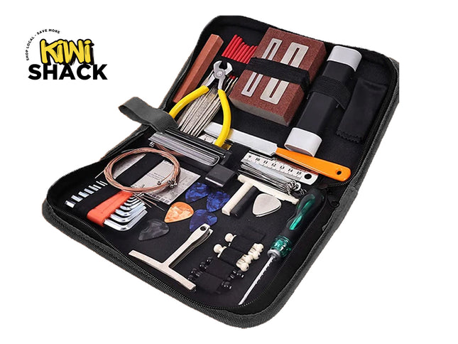 An open zippered black tool case containing various guitar maintenance and repair tools, including string cutters with yellow handles, hex keys, guitar picks, a string winder, a file, and a screwdriver, against a white background. A "Kiwi Shack" logo appears in the top-left corner.