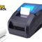 A black and blue thermal paper label printer shown on a white background with a roll of white paper and a Kiwi Shack logo in the top-left corner.