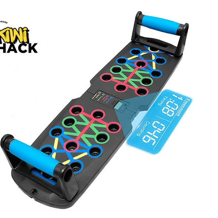 A black multi-color push-up board with blue padded handles and a digital counting screen display, set against a white background. A "Kiwi Shack" logo appears in the top-left corner.