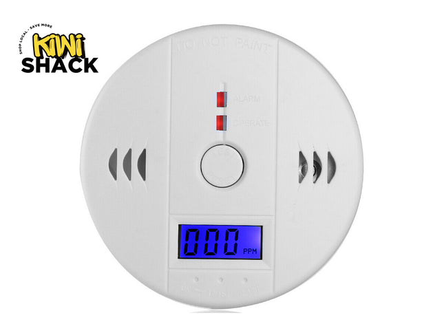 White round Smoke Alarm Detector with digital blue display reading 000 PPM, test/reset button, alarm and operate status indicator lights, side vent slots, "DO NOT PAINT" warning molded at the top, and Kiwi Shack logo in the top-left corner.