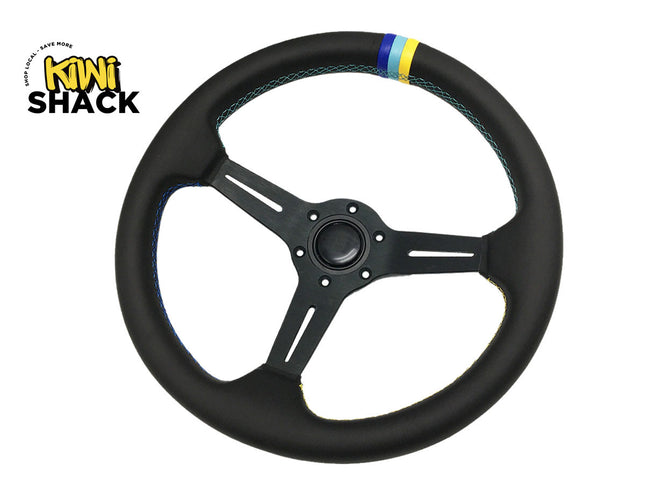 A black three-spoke racing steering wheel cover by Mini Shack, featuring a blue and yellow stripe accent near the top rim, shown on a white background with the Mini Shack logo in the upper left corner.