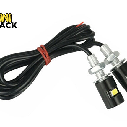 Pair of black bolt-on LED eagle eye lights with threaded mounting studs, nuts, washers, and long wired lead tied with red twist tie, featuring Kiwi Shack logo in top left.