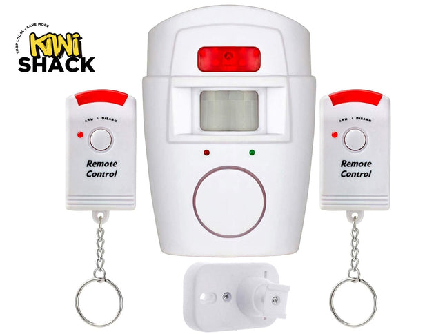A white infrared wireless motion sensor alarm system with a mounting bracket and two remote control keychains, featuring the "Kiwi Shack" logo in the top-left corner.