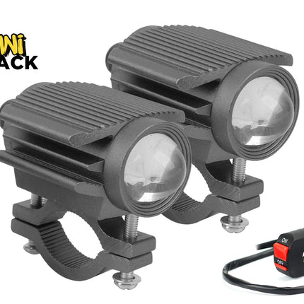 A pair of black auxiliary LED motorcycle spotlight pods with ribbed aluminum heat sinks, projector lenses, handlebar mounting clamps, and an on-off toggle switch, featuring a "Kiwi Shack" logo in the top left corner.