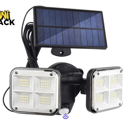 A dual-head solar-powered motion sensor LED floodlight featuring four square multi-LED diode panels on each light head, connected via a long cord to a separate photovoltaic solar panel against a white background, featuring the "Kiwi Shack" logo in the upper left corner.